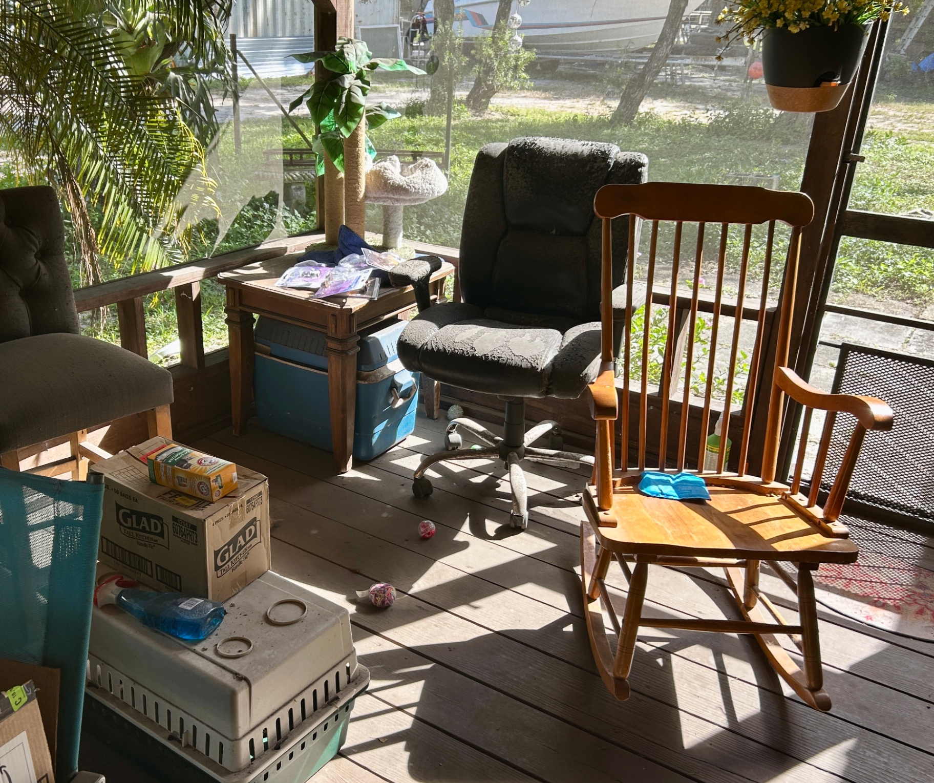 Cluttered porch with furniture, boxes, and household items during a downsizing cleanout in South Florida